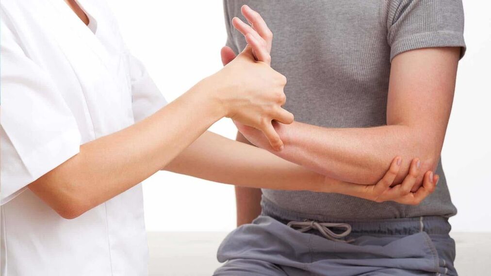 Ο γιατρός εξετάζει ένα χέρι με αρθρίτιδα
